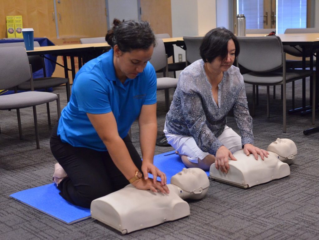 Two women performing CPR on dummies